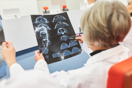 Female doctor examining medical x-ray during healthcare conference in auditorium