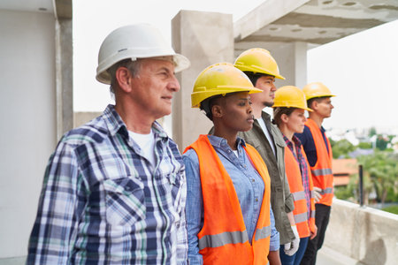 Team of workers in workwear looking awayの写真素材
