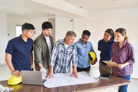 Team of workers and architect discussing blueprintの写真素材