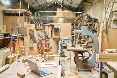 A bustling wood workshop filled with tools and machinery in a lumberyard, showcasing craftsmanship and manual work spaces, ready for creative projects and construction endeavors.の写真素材