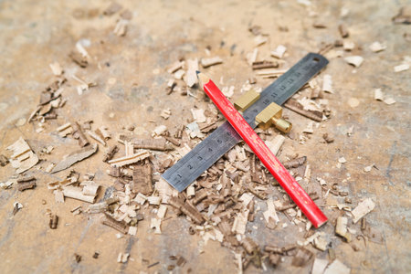 A detailed view of a ruler and pencil on a workbench surrounded by wood shavings, capturing the essence of craftsmanship and woodworking. Ideal for illustrating carpentry or DIY projects.の写真素材
