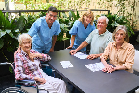 A group of senior adults and caregivers participating in a social activity in a rehabilitation...