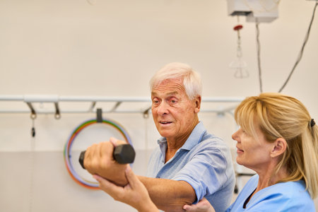 Elderly man participating in physical therapy with nurse assistance to improve mobility and...