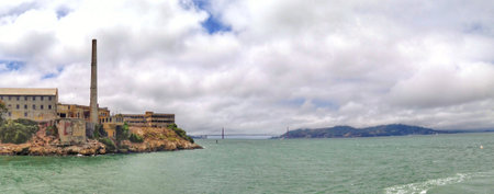 Wide panoramic view of a historic site near the water, with distant landmarks visible.の写真素材