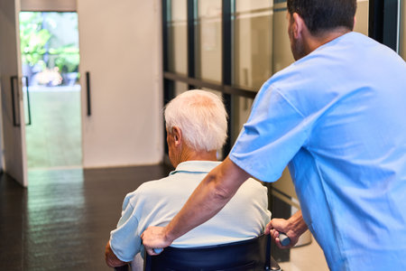 A nursing professional helps an elderly individual in a healthcare facility providing rehabilitation...