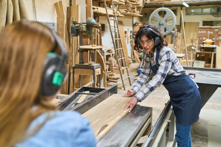 A lively lumberyard scene showing younger and older workers collaborating and engaging in teamwork....
