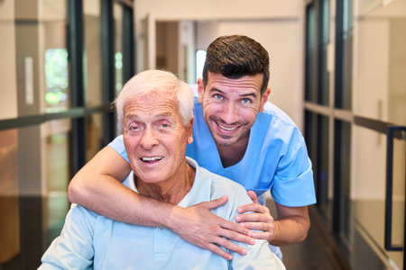 A friendly nurse and a senior man share a moment of joy in a healthcare facility. The image emphasizes caring, compassionate assistance, and positive interaction in a professional and supportive environment.の写真素材