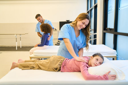 A nurse or physical therapist provides gentle care as a child rests on a pillow during a...