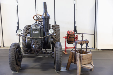 BERLIN, GERMANY, January 16th 2026: Photo of a vintage Lanz Bulldog tractor and a butter churn are on display at the Internationale GrÃ¼ne Woche trade fair in Berlin Germany The tractor and churn represent historical agricultural equipment.のeditorial素材