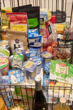 BERLIN, GERMANY, January 16th 2026: Photo of A shopping cart is filled with a variety of groceries at the Internationale GrÃ¼ne Woche trade fair in Berlin Germany The cart contains packaged foods dairy products beverages and other retail items on display.のeditorial素材