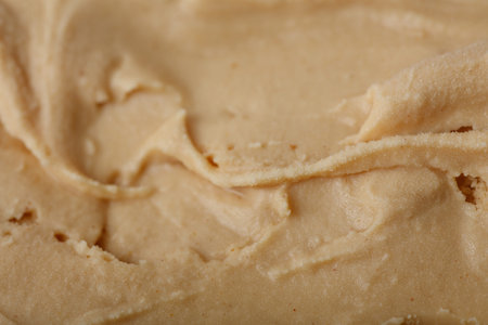 A high-detail macro shot of the surface of creamy peanut butter ice cream