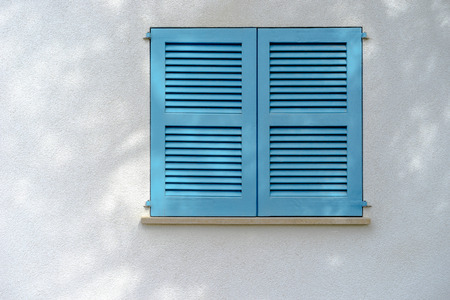 white wall with blue window stutterの写真素材