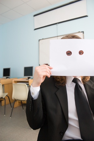 Young businessman is holding in hands clean sheet of a paper for your inscription の写真素材