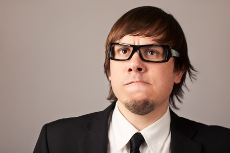 Close-up portrait of thinking businessman. On a gray background