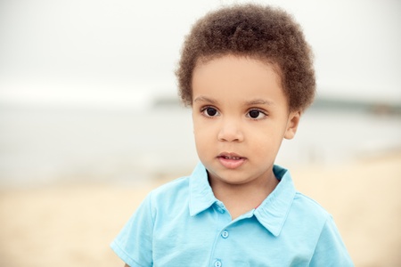 cute african american boy on a background of sand & seaの写真素材
