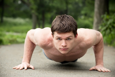 Push ups workout. Young man making pushups, outdoors