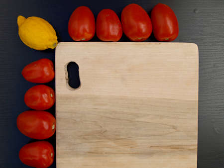 cutting board with lemon and tomatoesの写真素材