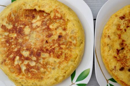 Potato tortillas on a plate and spicy vegetablesの写真素材