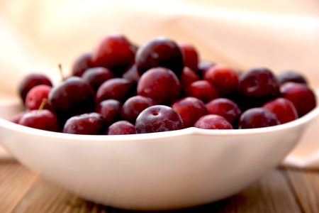 bowl with ripe red plumsの写真素材