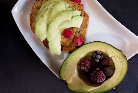 Toast with avocado, red fruits and cold drinkの写真素材