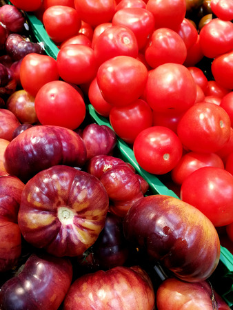 purple tomatoes and red tomatoes in the marketの写真素材