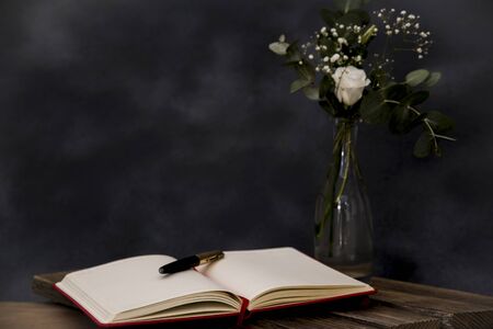 romantic bouquet and note book with pen foregroundの写真素材