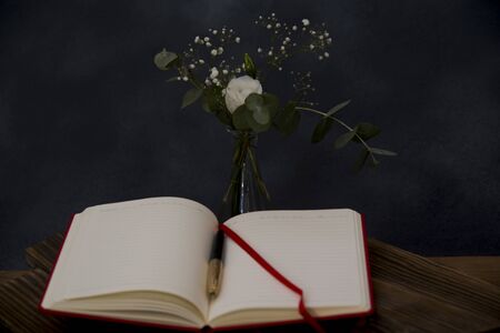 romantic bouquet and note book with pen foregroundの写真素材