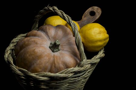 still life with pumpkin, quince, lemons and cane basketの写真素材