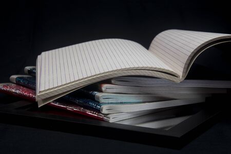 color full notebooks piled on black background