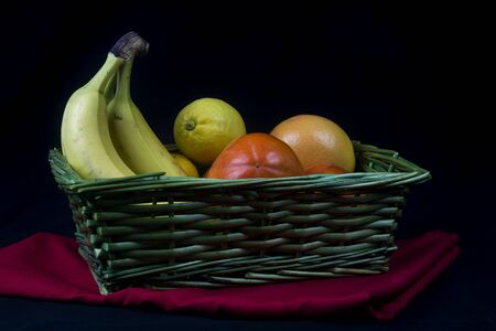 wicker basket with fruits in background with elegant clothの写真素材