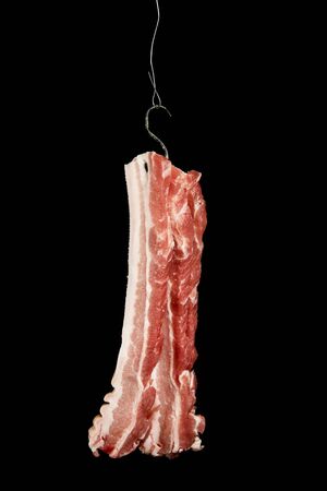bacon slices hanging on a hookの写真素材