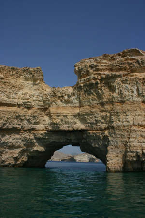 A hole in the mountain running into the sea. muscat, oman の写真素材