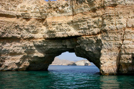 A hole in the mountain running into the sea. muscat, oman の写真素材