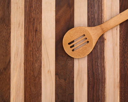 Slotted wood spoon on cutting board with copy spaceの写真素材