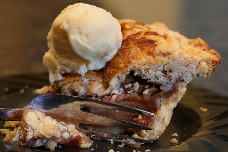 Slice of Apple Pie on plate with fork and ice cream