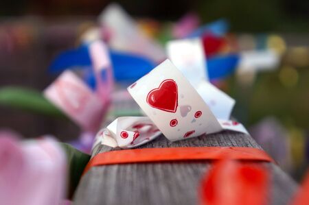 festive colorful ribbons with a heart on a fenceの写真素材