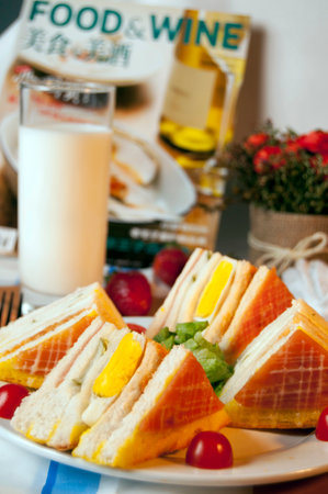 Sandwich with ham, cheese, tomatoes and a glass of milkの写真素材