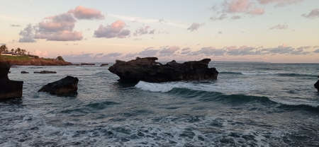 beach in bali with beautiful black rocksの写真素材