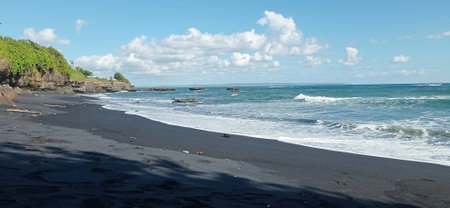 black sandy beach with wonderful blue sky in summerの写真素材