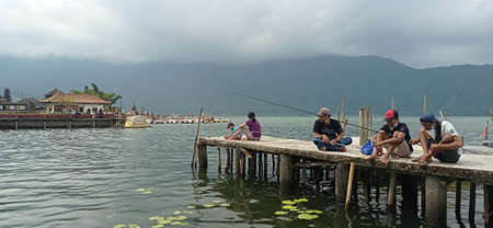 BALI, INDONESIA- May 15 2021: several people seem to be fishing in Lake Beratan, Bedugul, Bali.のeditorial素材