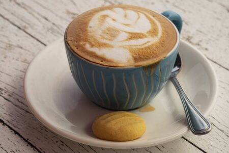 a cup of cappuccino with a piece of cake