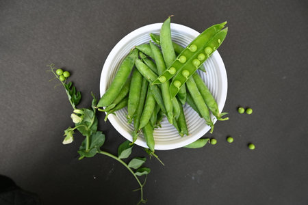 Fresh Green peas on black background. There is a lot of vitamins  and Minerals in it. TheÂ peaÂ is most commonly the small sphericalÂ seedÂ or the seed. Popular vegetable of world.の写真素材