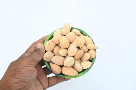 Almond in a bowl on white background. Almond in hand