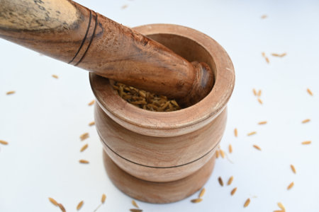 Pounding paddy with wooden mortar and pestle. Traditional method of food preparation. In the olden...