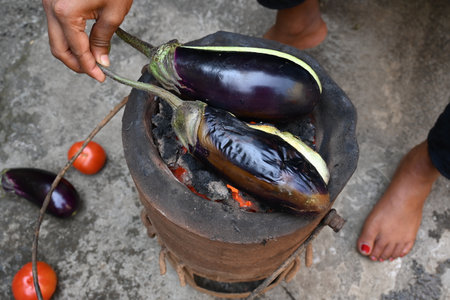 Roasting eggplant or Brinjal on a coal stove. By Roasting and Mashed it, a famous dish Baingan Ka Bharta is made. It is liked in almost all regions of India.の写真素材