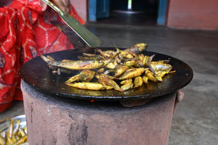 Small Snakehead or Channa orientalis Fish being fried in a pan. Its typically marinated with spices like turmeric, salt, and chili powder before being fried until they are crispy.の写真素材