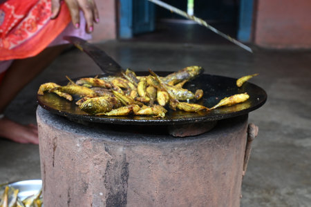 Small Snakehead or Channa orientalis Fish being fried in a pan. Its typically marinated with spices like turmeric, salt, and chili powder before being fried until they are crispy.の写真素材