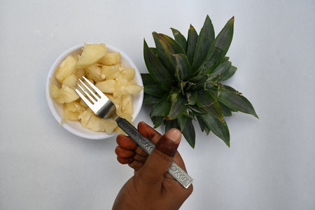 Pineapple or Ananas comosus slices on white background. It is aÂ tropical plantÂ with an edible fruit. It is plant in the familyÂ Bromeliaceae. Pineapple pieces in a bowl ready to eatの写真素材