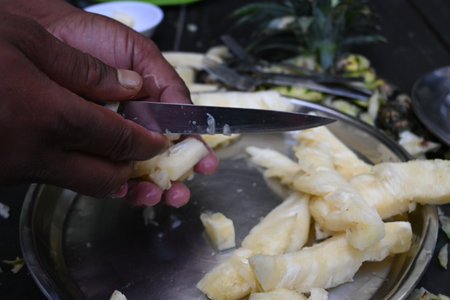 Pineapple or Ananas comosus chopping with knife. It is aÂ tropical plantÂ with an edible fruit. It is plant in the familyÂ Bromeliaceae. Fruits cutting.の写真素材