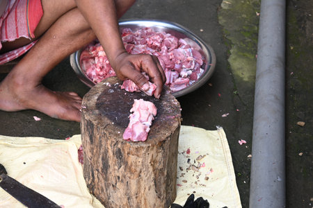 Chopping goat meat. Fresh raw or uncooked goats mutton cutting from Traditional iron tool in Indian...
